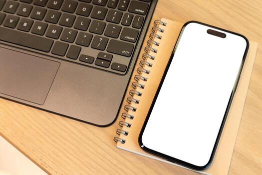 Blank Smartphone Screen on Notebook Beside Laptop. modern work, study, and business environments. mobile app mockups, educational content, UI UX designs, or representing remote work and planning. photo