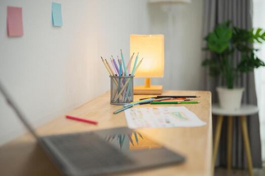 Cozy Workspace with Stationery, Laptop, and Natural Light in Modern Home Office Setting Featuring Creative Tools and Relaxing Atmosphere photo