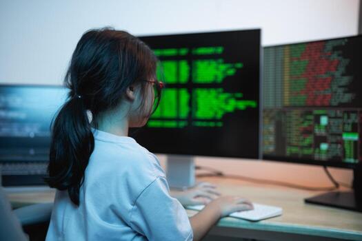 Child Engaged in Computer Programming with Multiple Monitors Displaying Coding Data and Tech Interface in Modern Workspace Setting photo