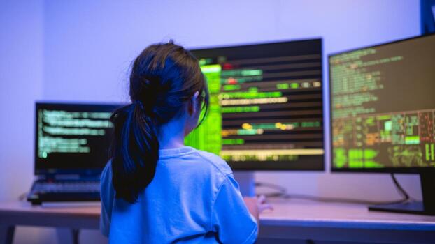 Young Girl Engaged in Coding Activity in a Dark Room with Multiple Computer Monitors Displaying Lines of Code and Data Visualization photo