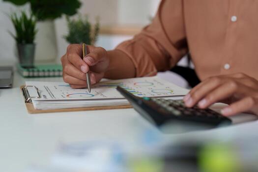 Budget Management. Professional calculating financial data with charts and calculator. photo