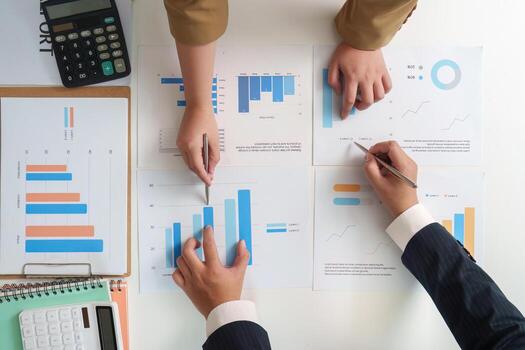 Data Analysis. Team reviewing financial graphs and statistics on a table. photo
