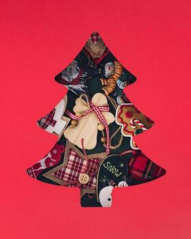 Winter composition with Xmas ornaments visible through a Christmas tree shaped gap on red background. Minimal Christmas and New Year concept. Creative festive holiday layout. Flat lay, top view. photo