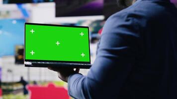 afrikansk amerikan tech entusiast ser på krom nyckel skärm Nästa till digital gränssnitt och multimedia bilder, visa upp innehåll skapande, mobil teknologi och global uppkopplad inflytande. kamera b. video