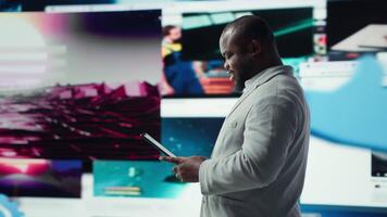 leende person använder sig av läsplatta, njuter fritid tid med uppkopplad innehåll. glad man bläddring social media app på enhet i främre av digital bakgrund fylld med clips collage layout, kamera en video