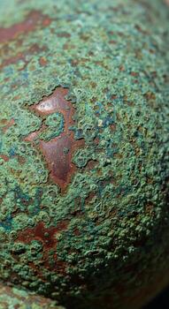 Close up view of weathered green paint with peeling texture and underlying reddish brown rust showing through photo