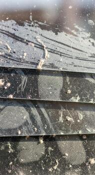 Close up textured abstract view of weathered and scratched dark metallic layered material with subtle reflections and debris photo