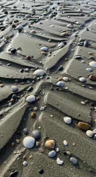 Intricate patterns of sand and pebbles form a natural abstract landscape on a beach during low tide photo