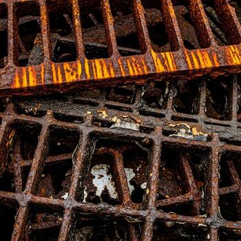 Close up view of two rusty metal grates one stacked on top of the other showing intricate patterns and textures of decay photo