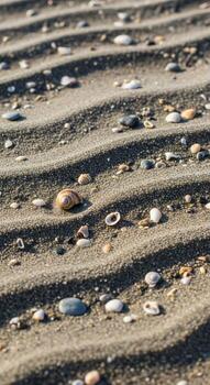 Close up view of rippled sand and small pebbles on a beach showing natural patterns and textures created by the tide photo
