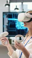 Vertikale weiblich Techniker tragen vr Brille Codierung mit ai Sprache Modell- Hilfe im Anfang Büro. jung Frau mit virtuell Wirklichkeit integrieren llm Assistent Vorschläge in Code Editor, Kamera ein video