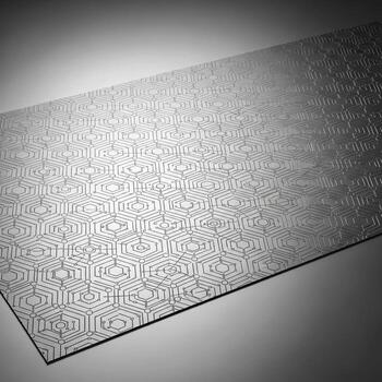 Close up of a textured metallic surface with a repeating geometric pattern under soft lighting photo