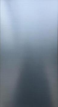 A serene abstract depiction of a foggy or cloudy sky transitioning into a darker textured surface below photo