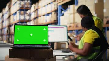 logistik anställd organisering paket nära isolerat attrapp på dator, införing beställa spårning verktyg och märkning system. personal medlem analyserar företag lager instrumentpaneler. kamera a. video