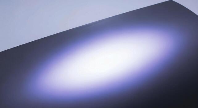 Abstract light bloom emanating from a dark surface creating a soft ethereal glow with subtle purple hues photo