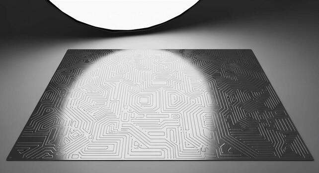 A textured metallic surface illuminated by a soft diffused overhead light creating a dramatic spotlight effect photo