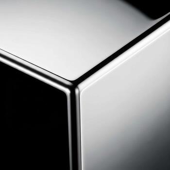 Abstract close up of a polished metal cube reflecting light and shadow with sharp edges photo