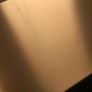 Close up view of a textured metallic surface with subtle light reflections and shadow patterns photo