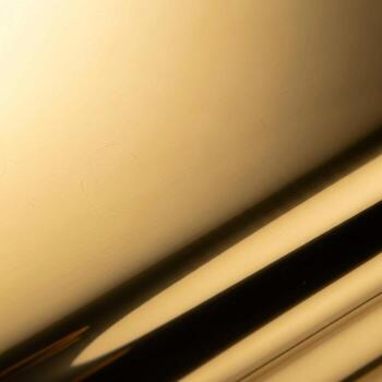 Close up abstract view of polished metallic surface with diagonal lines and soft golden light creating a luxurious and modern aesthetic photo