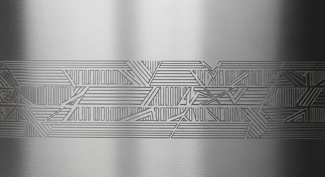 Close up of a brushed metal surface with a geometric etched pattern creating a textured abstract design with subtle light reflections photo