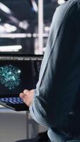 vertikal data Centrum programmerare använder sig av bärbar dator till övervaka neuralt nätverk använder sig av ai llm chatbot. arbetstagare använder sig av artificiell intelligens på anteckningsbok till övervaka servrar driver maskin inlärning, kamera en video