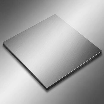 A polished reflective metallic square sheet with subtle lighting creating a gradient of light and shadow across its surface photo