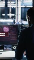 Vertical Annoyed data center programmer struggles with malfunctions while using AI tools. Frustrated server hub worker upset by errors while using artificial intelligence to optimize system health, camera A video