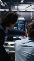 verticale server camera computer scienziati utilizzando ai per revisione infrastruttura diagnostica. esso specialisti Lavorando insieme nel dati centro, analizzando prestazione dati utilizzando artificiale intelligenza tecnologia, telecamera un' video