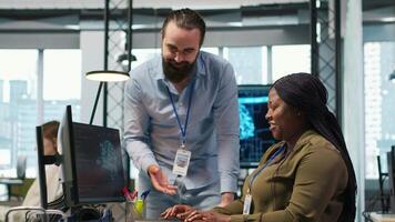 Joyous colleagues having fun during job shift break, doing bonding, concept of positive office culture. Workplace friends having playful discussion while using AI to optimize code, camera A video
