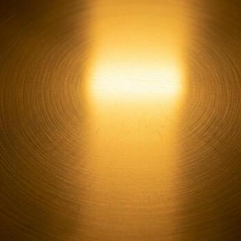 Warm golden light illuminates a textured surface creating a soft abstract glow with a central bright beam photo