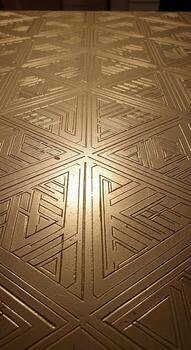 Intricate geometric pattern on a metallic surface with a warm golden hue and linear design photo