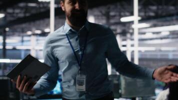 Data center lead programmer showcasing AI technology and rigs, filming presentation tour. Server room IT employee presenting artificial intelligence deep learning tech, camera A video
