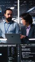 vertikal Lycklig data Centrum kollegor samarbetande på neuralt nätverk programvara utveckling. glad lagarbete server nav medarbetare genomförande maskin inlärning teknologi i arbetsplats, kamera en video