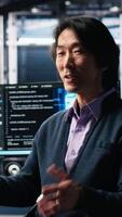 vertikal data Centrum administration vinka hand, filmning presentation Turné, visa upp stordatorer och ai teknologi. optimistisk asiatisk man i server rum presenter artificiell intelligens neuralt nät teknik, kamera en video