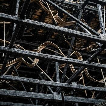 Intricate network of weathered wooden beams and structural supports forming a complex architectural framework photo