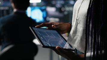 cerca arriba de datos centrar ingeniero utilizando tableta a revisión código para automatización guiones. servidor granja sistema administrador utilizando dispositivo, supervisión error registros para depuración procesos, cámara un video