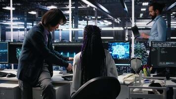 multiétnico equipo en diverso datos centrar codificación con asistencia. asiático hombre supervisa trabajo por eso experto apalancamiento artificial inteligencia grande idioma modelo, cámara un video