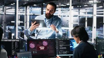 data Centrum chef samordnar programmerare fixering kritisk fel medan använder sig av ai. server rum team ledare övervaka arbetare reparation tekniskt fel dyka upp medan använder sig av artificiell intelligens, kamera en video