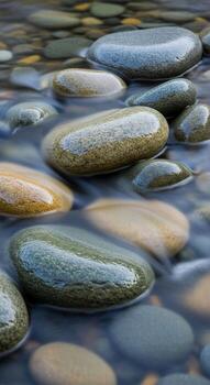 Smooth wet river stones with subtle color variations submerged in clear flowing water creating a tranquil natural pattern photo