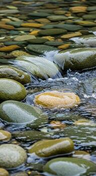 Smooth rounded river stones submerged in clear rippling water creating a natural serene texture photo