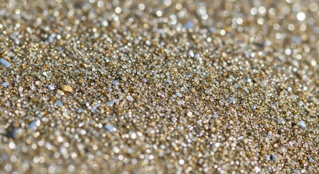 Close up abstract macro photograph of shimmering golden sand grains reflecting sunlight with subtle hints of color photo