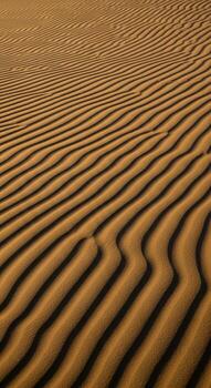 Abstract ripples of wind sculpted sand dunes creating a textured natural pattern of light and shadow photo