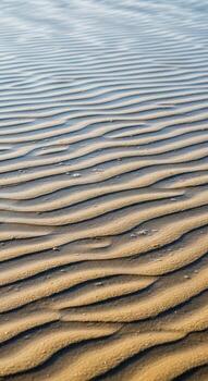 Abstract ripples of sand under a softly lit sky creating a textured natural pattern photo