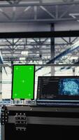 Vertical Green screen tablet in server room with machine learning technology detecting data patterns. Chroma key device in data center ensuring rapid data access and transfer rates for AI processing video