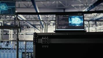 Artificial intelligence technology on notebook in industrial data center facility helping power internet services. AI coding script running on laptop in server farm built for digital storage systems video