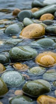 Smooth rounded river stones submerged in clear flowing water creating a serene and natural abstract pattern photo