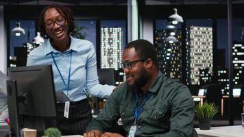 afrikansk amerikan arbetare grupp analyserar prestanda metrik på skrivbordet med hög teknik, inriktning företag strategi och mål till kör resultat inom en multinationell företag. kamera b. video