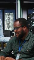 Vertical African american workers group analyzing performance metrics at desktop with high tech, aligning business strategy and objectives to drive results within a multinational company. Camera B. video