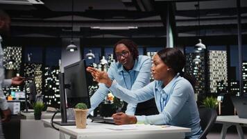Team of black staff members working with finances data and performance metrics, aligning vision and objectives to drive success within a multinational company environment at night. Camera A. video
