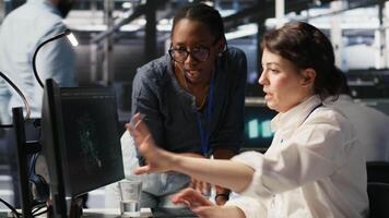 Data center technicians adjusting blade server hardware powering artificial intelligence processing operations. Coworkers oversee server arrays handling training datasets infrastructure, camera A video